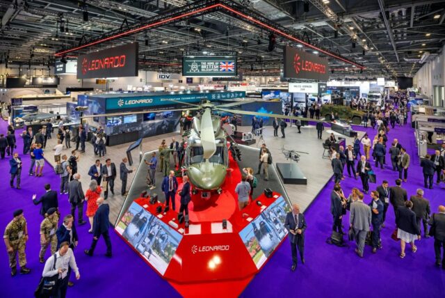 Crowd attending DSEI UK defence and security exhibition in London with military vehicles and industry stands on display